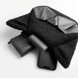 ORIBAGU ネコ型ミニバッグの収納例。ポーチの中からスマートフォン、鍵、二つ折り財布、モバイルバッテリーが顔を出している様子。コンパクトな外見ながら、外出に必要な最小限のアイテムがしっかり収まる容量を示すカット。